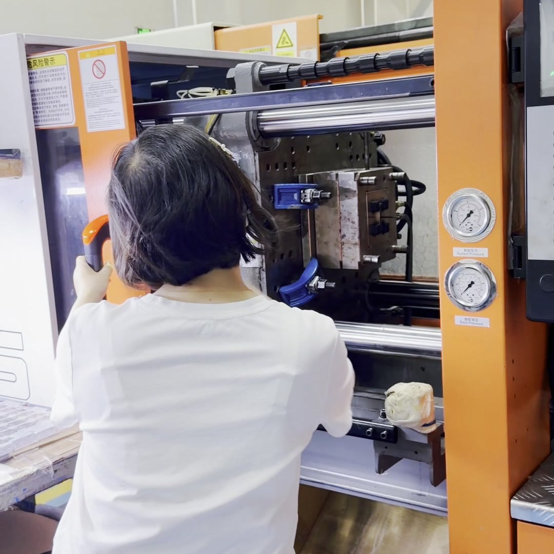 JingZhan operator checking an injection moulding machine and mould area